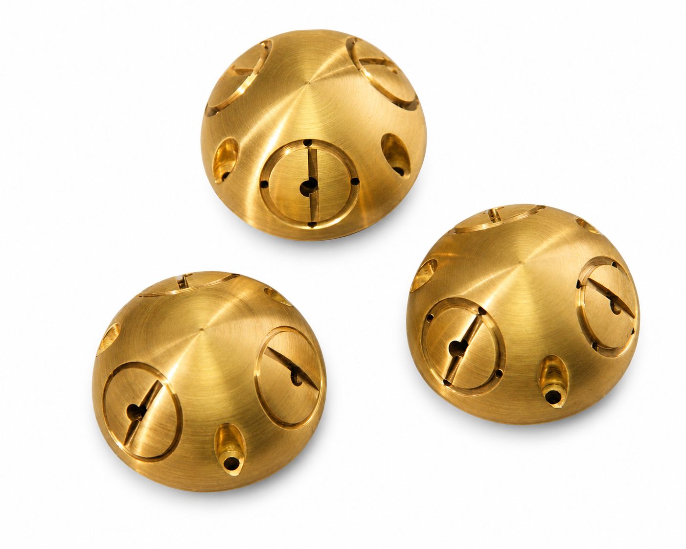 Drie gedraaide messing halfbollen met gefreesde uitsparingen